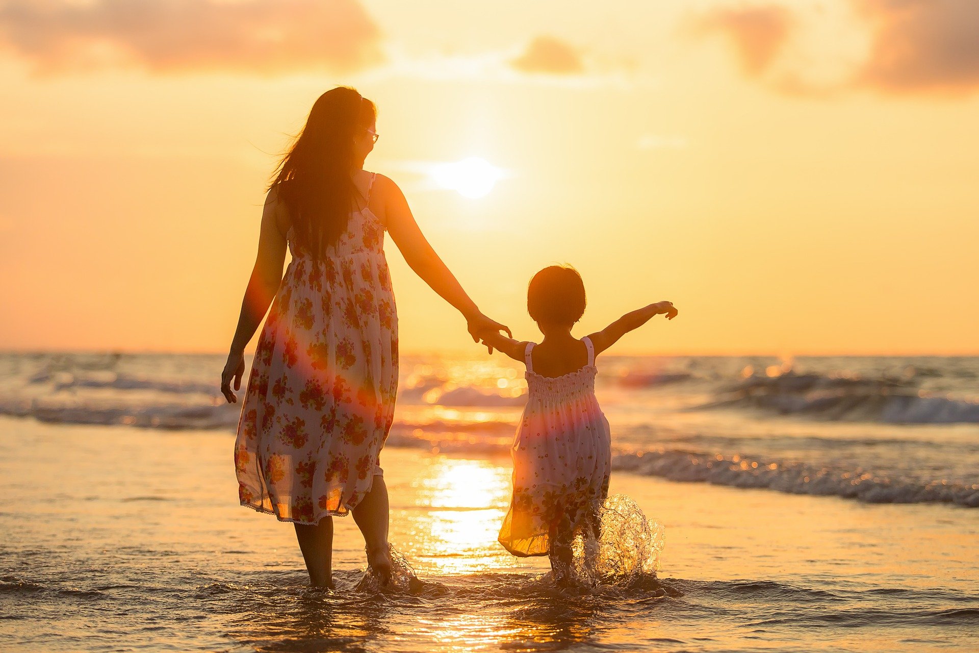 imagen madre e hija caminando hacia la playa